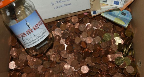 eine geöffnete Pappschachtel mit Kleingeld, Geldscheinen und einem Brief